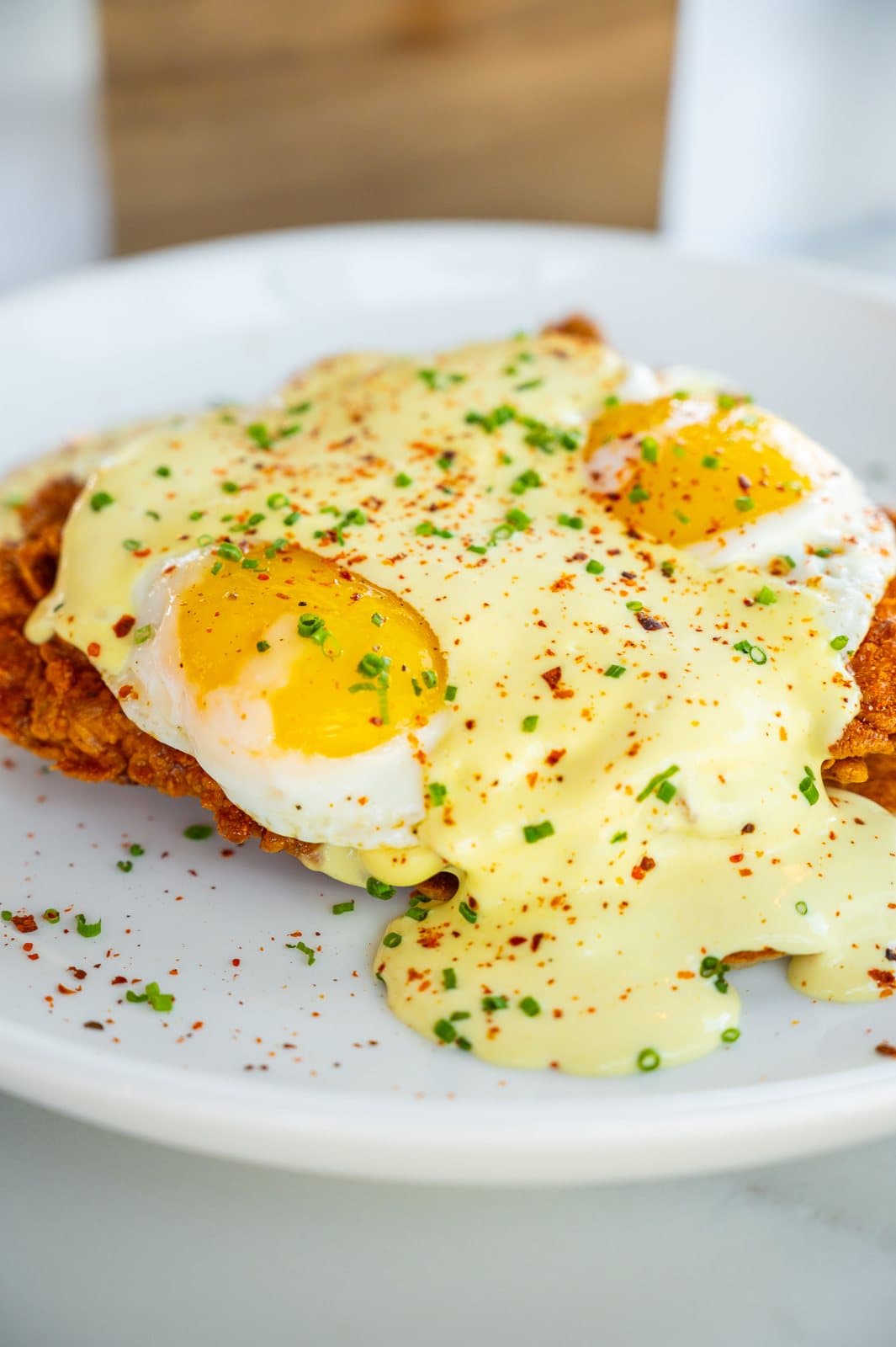 Crispy chicken under two sunny eggs and hollandaise with chives
